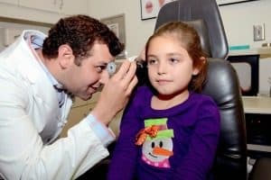 Pediatric ENT specialist looking into a patient's ear during her appointment for cochlear implants in Birmingham, AL